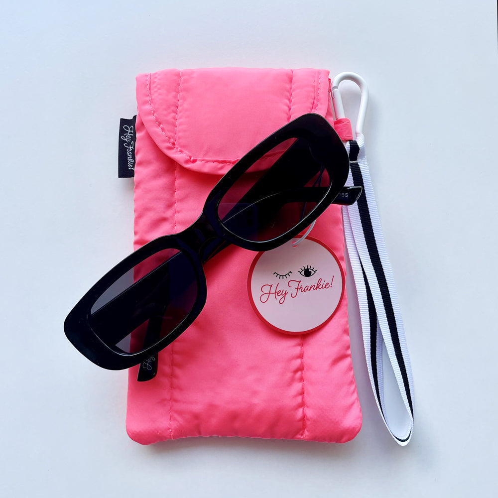 Teenage girls black sunglasses resting on neon sunglasses pouch